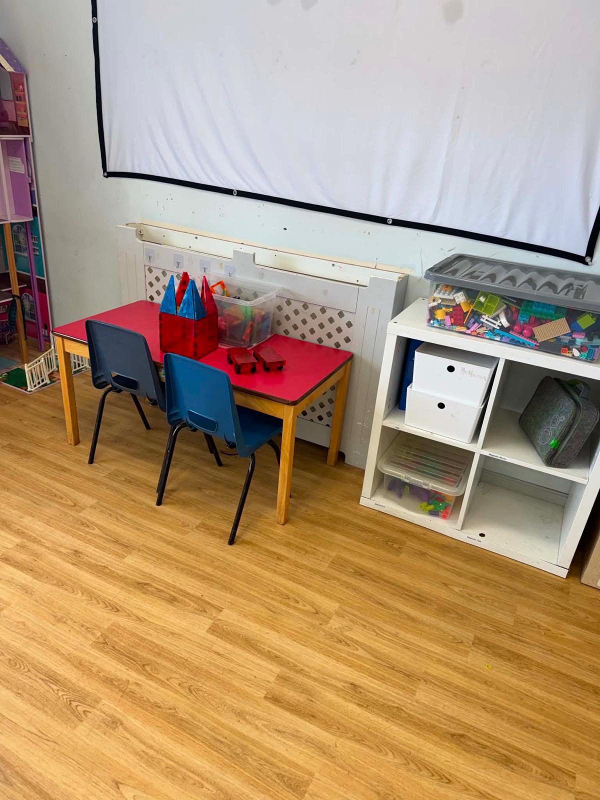 An activity table with magnetic tiles and boxes of Lego