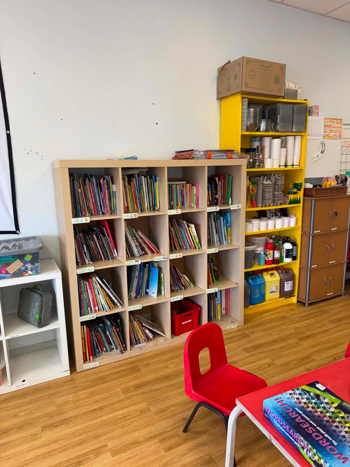The book library, sorted into labelled categories, beside the craft shelves