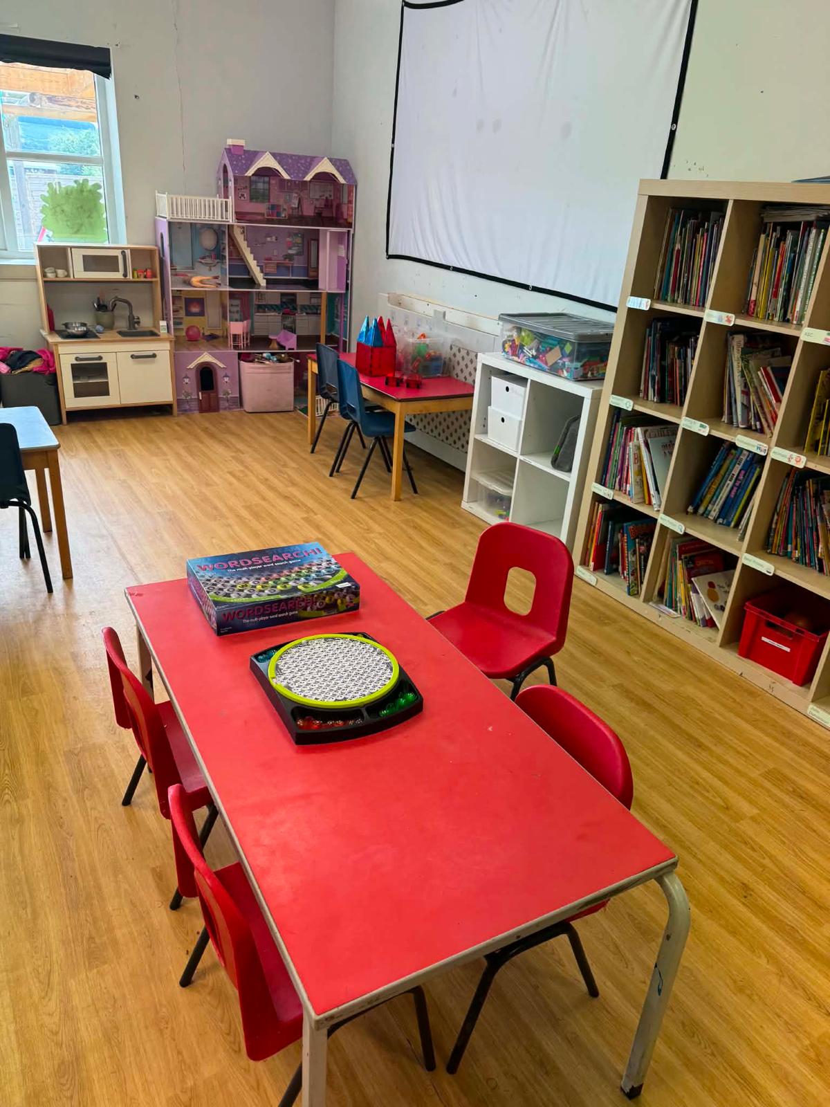 The After School Club room — a big book library, board games and a play kitchen