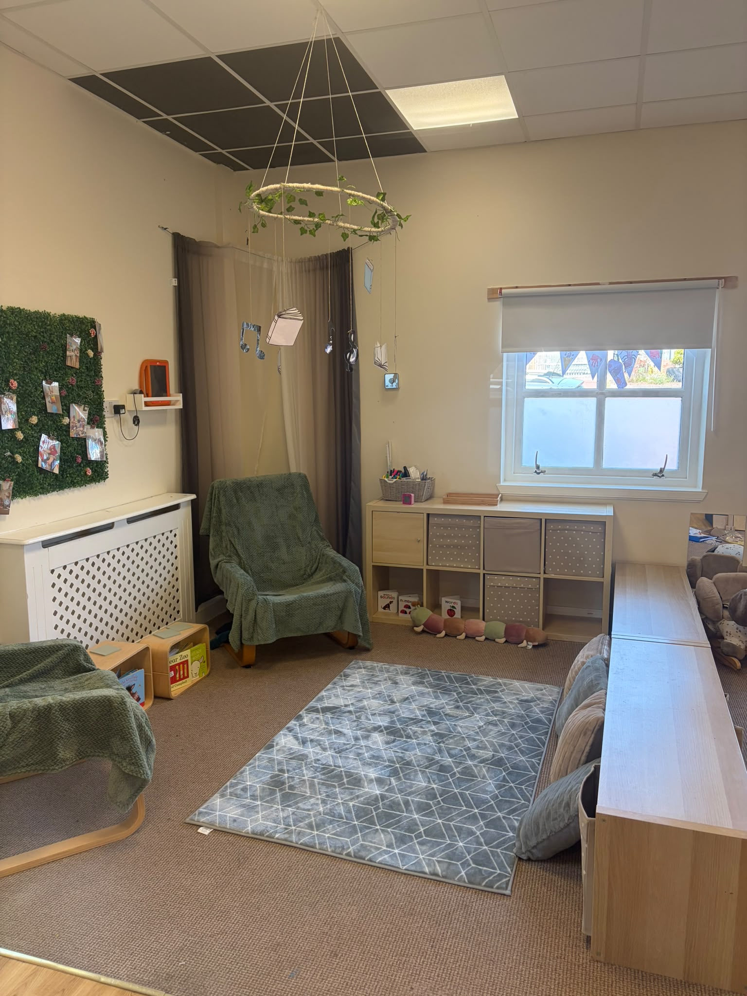 Quiet book corner with reading chairs and a hanging book mobile