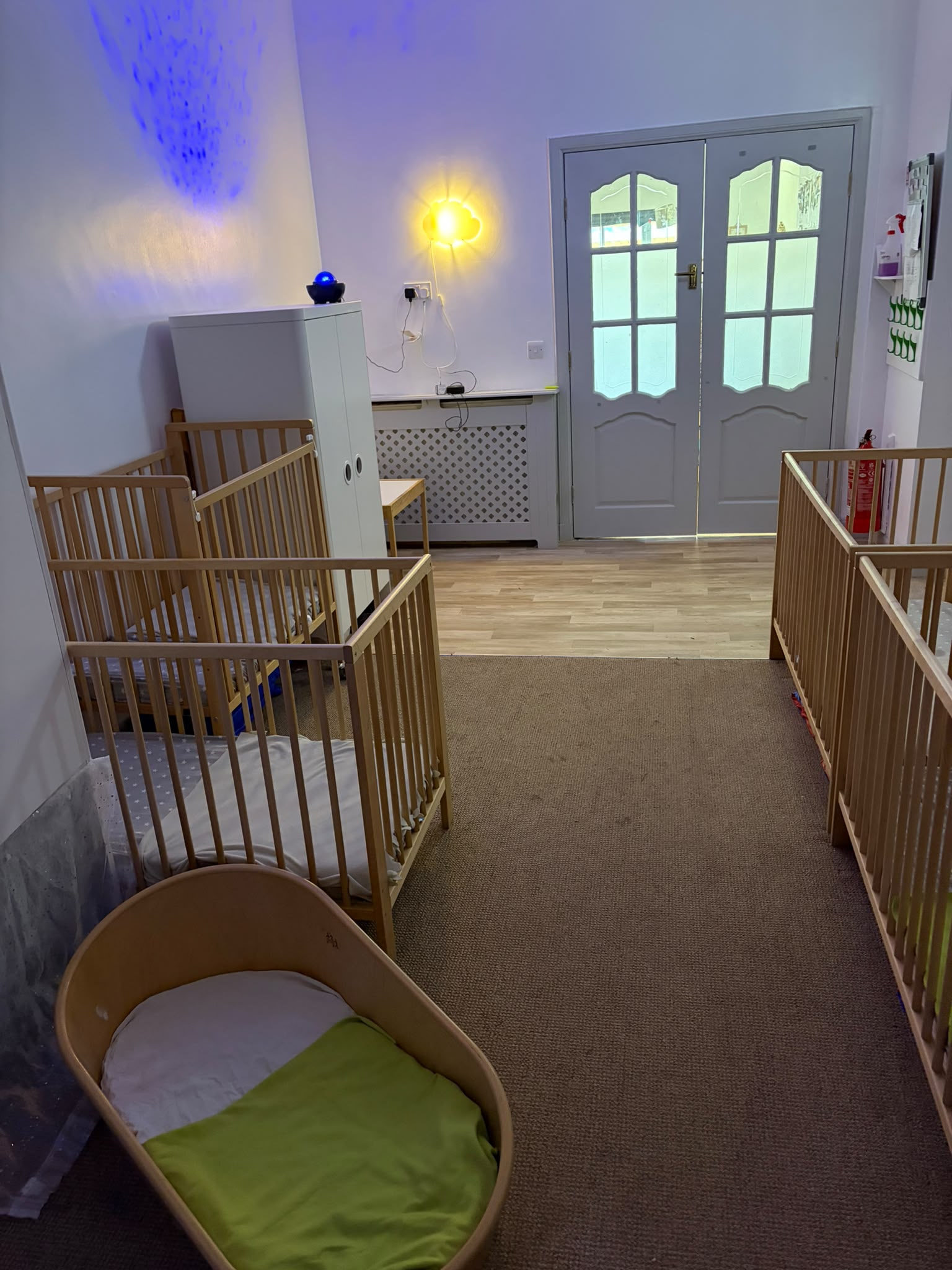 The baby sleep room, softly lit with a cloud light and star projector