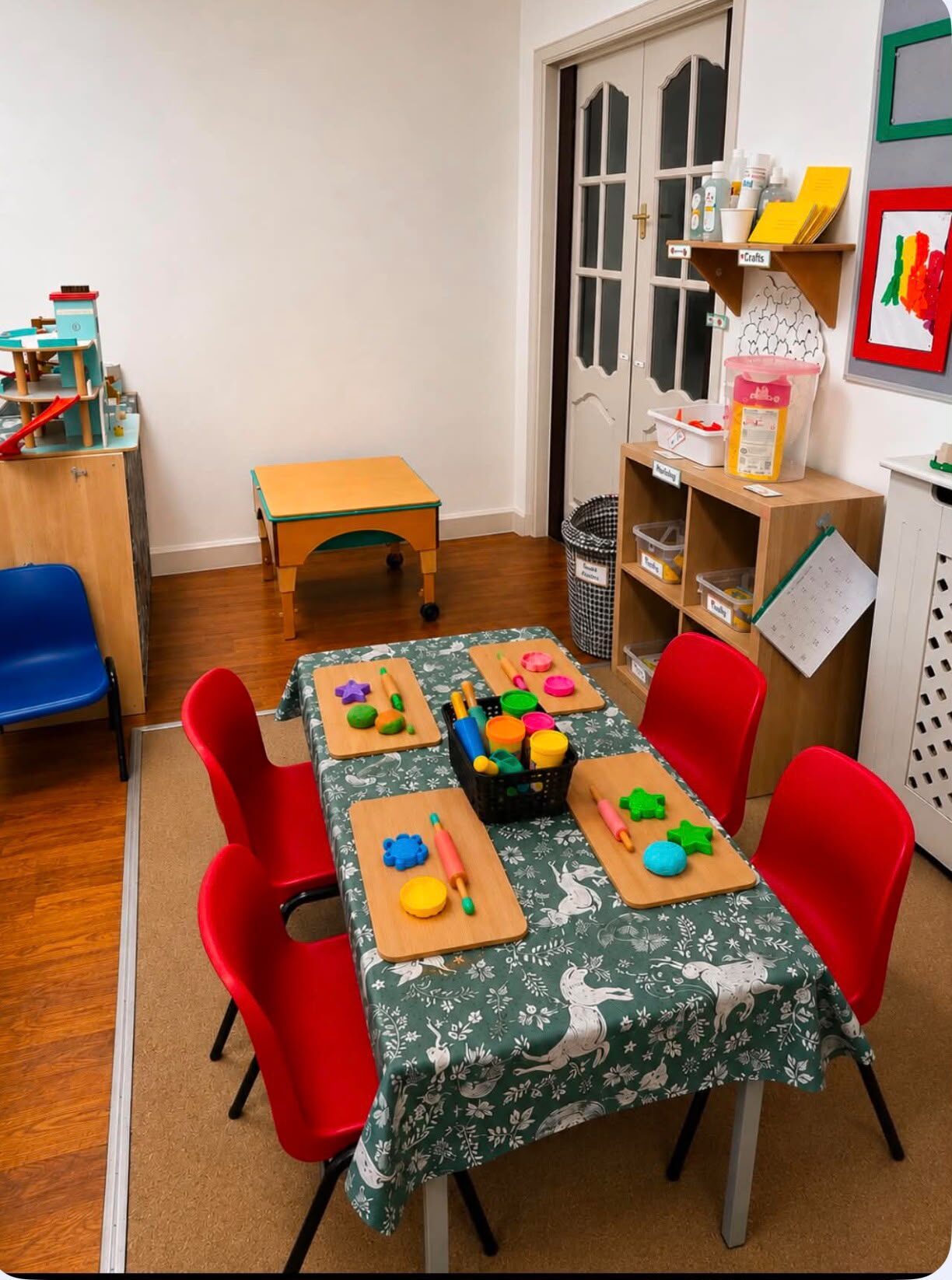 Playdough table set with wooden boards, rolling pins and colourful dough shapes